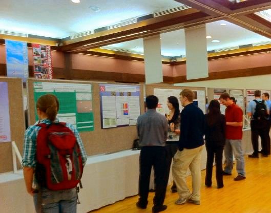 Photo of people talking with poster presenters at the University of Nebraska-Lincoln's Undergraduate Research Fair